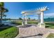 A pergola sits on a brick path near the tennis court and community pool, adding charm at 519 Purslane Pt, Venice, FL 34293