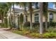 Beautiful home exterior featuring lush landscaping, palm trees, and decorative columns at 519 Purslane Pt, Venice, FL 34293