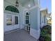 Inviting front entrance with double doors, arched windows, and decorative columns under a covered porch at 519 Purslane Pt, Venice, FL 34293