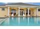 Relax by the pool with a view of the clubhouse, which provides a tranquil backdrop at 519 Purslane Pt, Venice, FL 34293