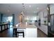 Well-lit kitchen with stainless appliances, white cabinets, an island, and easy access to the living area at 9558 Brave Buck Ave, Land O Lakes, FL 34638