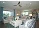 Bright living room with comfortable seating, ceiling fan, and an open view to the modern kitchen at 9558 Brave Buck Ave, Land O Lakes, FL 34638