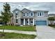 Charming two-story home features a blue garage door, blue shutters, a manicured lawn, and a classic facade at 9572 Brave Buck Ave, Land O Lakes, FL 34638