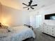 Bright bedroom with carpet, featuring a bed with decorative pillows, a ceiling fan, and a dresser at 3708 Alafia Creek St, Plant City, FL 33567
