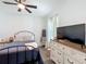 Charming bedroom with a cozy bed, a ladder-style blanket rack, and a rustic dresser with a TV at 3708 Alafia Creek St, Plant City, FL 33567