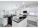 Modern kitchen featuring white cabinets, a large island with black countertops, and stainless steel appliances at 3708 Alafia Creek St, Plant City, FL 33567
