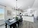 Open kitchen and dining area featuring white cabinets, black countertops and modern light fixture at 3708 Alafia Creek St, Plant City, FL 33567