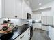 Updated kitchen showcasing white cabinetry, black countertops, and stainless steel appliances at 3708 Alafia Creek St, Plant City, FL 33567