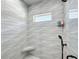 Bright shower stall with textured tile walls, a small shelf, and a built-in tiled corner seat at 3708 Alafia Creek St, Plant City, FL 33567