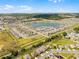 Scenic aerial perspective of the community with a beautiful lake and expansive green spaces at 38370 Sonnet Landing Ave, Zephyrhills, FL 33540