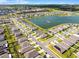 An aerial view of a Primary-planned community with a central lake and neatly arranged residential streets at 38370 Sonnet Landing Ave, Zephyrhills, FL 33540