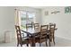 Bright dining area featuring a wooden table with seating for six, a sliding glass door, and neutral décor at 38370 Sonnet Landing Ave, Zephyrhills, FL 33540