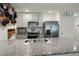 Well-lit kitchen boasting stainless steel appliances, a granite countertop island, and light gray cabinetry at 38370 Sonnet Landing Ave, Zephyrhills, FL 33540