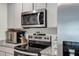 Close-up of kitchen featuring stainless steel microwave, oven, and refrigerator at 38370 Sonnet Landing Ave, Zephyrhills, FL 33540