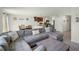 Bright living room featuring a sectional sofa, a view of the dining area, and a modern open-concept layout at 38370 Sonnet Landing Ave, Zephyrhills, FL 33540