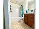 Well-lit bathroom with a shower, toilet, and a wooden vanity at 6698 Wirevine Dr, Brooksville, FL 34602