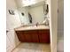 Cozy bathroom featuring wooden cabinets, a wide mirror, and neutral decor at 6698 Wirevine Dr, Brooksville, FL 34602