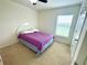 Bright bedroom with carpet, window, and a bed featuring a lilac comforter at 6698 Wirevine Dr, Brooksville, FL 34602