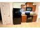 Kitchen showcasing modern black appliances, wood cabinets, and neutral tile flooring at 6698 Wirevine Dr, Brooksville, FL 34602
