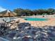 Community pool surrounded by a decorative brick patio, lounge chairs, and a privacy fence at 6698 Wirevine Dr, Brooksville, FL 34602