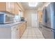 Functional kitchen featuring a stainless steel refrigerator and light wood cabinets, plus a white tile floor at 5330 Dr Martin Luther King Jr St S, St Petersburg, FL 33705