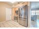 Kitchen with stainless steel appliances and light wood cabinetry and white tile floor is well-lit by an overhead light at 5330 Dr Martin Luther King Jr St S, St Petersburg, FL 33705