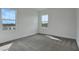 Bright bedroom featuring neutral carpeting, two windows, and white walls at 200 Eagleston Ln, Lakewood Ranch, FL 34240