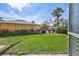 A spacious backyard with lush green grass, privacy bushes, and access to the community pool and lounging area at 12300 Vonn Rd # 1102, Largo, FL 33774