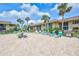 Seating and grills surround the community pool, shaded by palm trees and umbrellas, creating a relaxing atmosphere at 12300 Vonn Rd # 1102, Largo, FL 33774