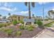 A sign for Villas de Golf with lush landscaping in front of low-rise buildings under a blue sky at 12300 Vonn Rd # 1102, Largo, FL 33774