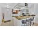 Kitchen with granite countertops, white cabinets, and bar seating, adjacent to a door and a window at 12300 Vonn Rd # 1102, Largo, FL 33774