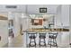Kitchen bar with granite countertop, seating, and view into a small seating area and the kitchen space at 12300 Vonn Rd # 1102, Largo, FL 33774