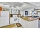 Bright kitchen with white cabinets, granite countertops, and modern appliances open to living room at 12300 Vonn Rd # 1102, Largo, FL 33774