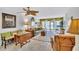 Comfortable living room with neutral colors, tropical decor, a ceiling fan, and sliding glass doors to the patio at 12300 Vonn Rd # 1102, Largo, FL 33774
