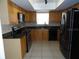Spacious kitchen with tile flooring, black appliances, and ample cabinet space at 15120 Brushwood Dr, Tampa, FL 33624