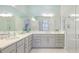 Bright primary bathroom with double sinks, white cabinets and a glass shower at 283 Saint Lucia Dr # 101, Bradenton, FL 34209