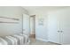 Cozy bedroom with coastal artwork, light wood floors and an open doorway to ensuite bathroom at 283 Saint Lucia Dr # 101, Bradenton, FL 34209