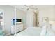 Light and airy bedroom with a four-poster bed, a large window with shutters, and a view of the bathroom at 283 Saint Lucia Dr # 101, Bradenton, FL 34209