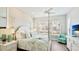 Light and airy bedroom features a four-poster bed, wood accent wall and large window with shutters at 283 Saint Lucia Dr # 101, Bradenton, FL 34209