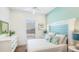 Inviting bedroom featuring a serene teal accent wall, white furniture, and coastal-themed decor at 283 Saint Lucia Dr # 101, Bradenton, FL 34209