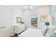Airy bedroom featuring a window, white dresser, coastal artwork, and complementary decor at 283 Saint Lucia Dr # 101, Bradenton, FL 34209