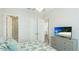 Bright bedroom featuring a patterned bedspread, white trim, and access to an ensuite bathroom at 283 Saint Lucia Dr # 101, Bradenton, FL 34209