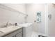 Practical laundry area with modern machines, a sink, granite countertops, and storage shelves at 283 Saint Lucia Dr # 101, Bradenton, FL 34209