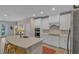 Bright kitchen with white cabinets, stainless steel appliances, and island seating at 7575 Sea Oak Ct, Parrish, FL 34219