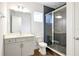 Modern bathroom with gray vanity, sleek fixtures, and glass enclosed shower with dark tile at 9608 Brave Buck Ave, Land O Lakes, FL 34638
