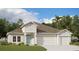 Charming single-Gathering home boasts a blue door, three-car garage and lush landscaping at 9608 Brave Buck Ave, Land O Lakes, FL 34638