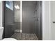 Elegant shower features dark gray subway tile, a frameless glass door, and mosaic tile flooring at 9608 Brave Buck Ave, Land O Lakes, FL 34638