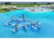 Aerial view of a waterpark in the lagoon with several inflatables, slides, and play structures at 11728 June Briar Loop, San Antonio, FL 33576