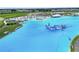 Amazing aerial view of a community lagoon with beach and large inflatable waterpark at 11728 June Briar Loop, San Antonio, FL 33576