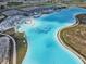 Stunning aerial view of a community lagoon with beach, island, and inflatable waterpark at 11728 June Briar Loop, San Antonio, FL 33576
